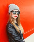 Adatti a ritratto la donna alla moda che indossa un bomber e gli occhiali da sole del nero della roccia immagine stock libera da diritti Adatti a ritratto la donna alla moda che indossa un bomber e gli occhiali da sole del nero della roccia immagine stock libera da diritti