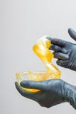 adoce o mel da pasta ou da cera para o cabelo que remove com as mãos pretas das luvas do cosmetologist no salão de beleza dos ter imagens de stock adoce o mel da pasta ou da cera para o cabelo que remove com as mãos pretas das luvas do cosmetologist no salão de beleza dos ter imagens de stock