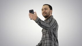 Adolescent faisant un selfie en marchant sur le fond de gradient images stock Adolescent faisant un selfie en marchant sur le fond de gradient images stock