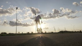 Adolescente allegro che si rilassa sulla guida della bici e che fa i trucchi con il tramonto nel fondo - stock footage Adolescente allegro che si rilassa sulla guida della bici e che fa i trucchi con il tramonto nel fondo - stock footage