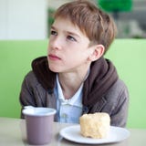 Adolescente in caffè che mangia alimenti a rapida preparazione immagini stock Adolescente in caffè che mangia alimenti a rapida preparazione immagini stock