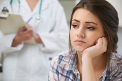 Adolescente con la cita en Surgery del doctor imagen de archivo libre de regalías Adolescente con la cita en Surgery del doctor imagen de archivo libre de regalías