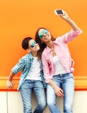 Adolescente felice del figlio e della madre che prende l'autoritratto dell'immagine sullo smartphone in città Immagine Stock Libera da Diritti Adolescente felice del figlio e della madre che prende l'autoritratto dell'immagine sullo smartphone in città Immagine Stock Libera da Diritti