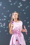 Adolescente nelle bolle di sapone di salto del bello vestito fotografia stock libera da diritti Adolescente nelle bolle di sapone di salto del bello vestito fotografia stock libera da diritti