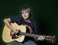 Adolescente que toca una guitarra fotos de archivo Adolescente que toca una guitarra fotos de archivo