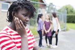 Adolescente triste se sentant gauche par des amis Images stock Adolescente triste se sentant gauche par des amis Images stock