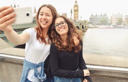 Adolescentes bonitos sonrientes felices que toman el selfie en Big Ben, Londres imagen de archivo libre de regalías Adolescentes bonitos sonrientes felices que toman el selfie en Big Ben, Londres imagen de archivo libre de regalías