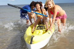 Adolescents en mer avec le canoë Images stock Adolescents en mer avec le canoë Images stock