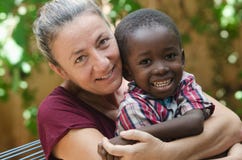 Adoptionsymbol - kvinnan adopterar lite den afrikanska pojken royaltyfri foto Adoptionsymbol - kvinnan adopterar lite den afrikanska pojken royaltyfri foto