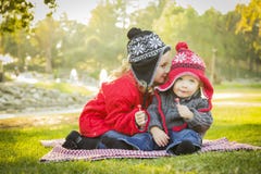 Adorable Girl Whispers Secrets to Baby Brother Outdoors royalty free stock photography Adorable Girl Whispers Secrets to Baby Brother Outdoors royalty free stock photography