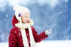 Adorable little girl having fun in beautiful winter park. Cute child playing in a snow. royalty free stock photo Adorable little girl having fun in beautiful winter park. Cute child playing in a snow. royalty free stock photo