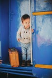 Adorable little kid boy dressed in red sweater on a railway station stock photography Adorable little kid boy dressed in red sweater on a railway station stock photography
