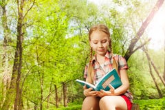 Adorable relaxed girl reading a book outdoor royalty free stock photo Adorable relaxed girl reading a book outdoor royalty free stock photo