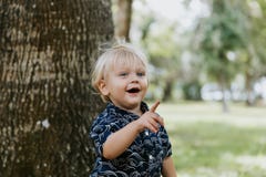 Adorably Happy And Cute Little Caucasian Toddler Baby Boy With Long Blond Hair Laughing, Playing, And Running Outside In Green Nat Stock Photography Adorably Happy And Cute Little Caucasian Toddler Baby Boy With Long Blond Hair Laughing, Playing, And Running Outside In Green Nat Stock Photography