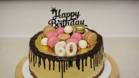 Adornando la torta con las galletas del macaron, los caramelos y las bolas blancas del chocolate para la fiesta de cumpleaños de Adornando la torta con las galletas del macaron, los caramelos y las bolas blancas del chocolate para la fiesta de cumpleaños de
