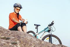 Adult attractive female cyclist resting outdoor,looking at s Royalty Free Stock Photos Adult attractive female cyclist resting outdoor,looking at s Royalty Free Stock Photos