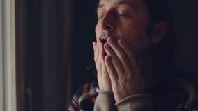 Adult caucasian sad man standing by the window of his living room and crying in despair stock video footage Adult caucasian sad man standing by the window of his living room and crying in despair stock video footage