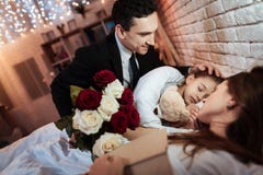 Adult man with roses bouquet is put to bed small daughter to sleep. Child is sleeping. stock images Adult man with roses bouquet is put to bed small daughter to sleep. Child is sleeping. stock images