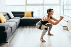 Adult Woman Training Legs Doing Side Squat at Home royalty free stock photo Adult Woman Training Legs Doing Side Squat at Home royalty free stock photo