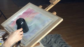 Adult women paint with colored watercolor paints and dry with a hair dryer in an art school stock footage Adult women paint with colored watercolor paints and dry with a hair dryer in an art school stock footage