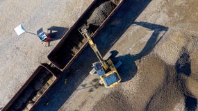 Aerial photo of an excavator loading a wagon with gravel stock photo Aerial photo of an excavator loading a wagon with gravel stock photo