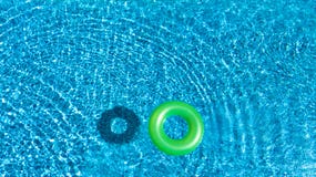 Aerial view of colorful inflatable ring donut toy in swimming pool water from above Royalty Free Stock Photography Aerial view of colorful inflatable ring donut toy in swimming pool water from above Royalty Free Stock Photography