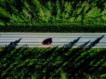 Aerial view of a country road with red car in the middle of green summer forest royalty free stock photo Aerial view of a country road with red car in the middle of green summer forest royalty free stock photo