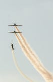 Aerobatic Flugzeug steuert Training im Himmel der Bukarest-Stadt, Rumänien Farbiges Flugzeug mit Spurnrauche Lizenzfreies Stockbild Aerobatic Flugzeug steuert Training im Himmel der Bukarest-Stadt, Rumänien Farbiges Flugzeug mit Spurnrauche Lizenzfreies Stockbild