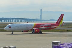 Aeroplano que lleva en taxi en la pista del aeropuerto de Kansai imagen de archivo Aeroplano que lleva en taxi en la pista del aeropuerto de Kansai imagen de archivo