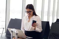 Affaires de Breaktime Belle femme d'affaires travaillant sur l'ordinateur portable tout en attendant son vol dans un aéroport images libres de droits Affaires de Breaktime Belle femme d'affaires travaillant sur l'ordinateur portable tout en attendant son vol dans un aéroport images libres de droits