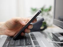 Affärsman som i regeringsställning arbetar med mobiltelefonen och datoren royaltyfri foto Affärsman som i regeringsställning arbetar med mobiltelefonen och datoren royaltyfri foto