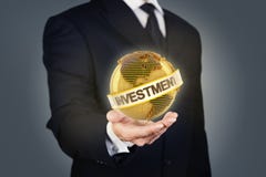 Affärsman som rymmer ett guld- jordklot med investering arkivbilder Affärsman som rymmer ett guld- jordklot med investering arkivbilder