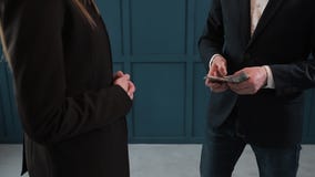 Affärsman som räknar dollarsedlar Ett affärsavtal med överföringen av pengar Närbilden av mannen ger en bunt av lager videofilmer Affärsman som räknar dollarsedlar Ett affärsavtal med överföringen av pengar Närbilden av mannen ger en bunt av lager videofilmer