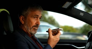 Affärsman som talar på mobiltelefonen i en bil 4k arkivfilmer Affärsman som talar på mobiltelefonen i en bil 4k arkivfilmer
