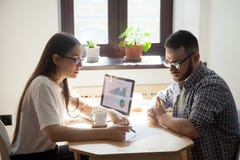 Affärsmöte: två millennial coworkers som löser funktionsdugligt sökande royaltyfria bilder Affärsmöte: två millennial coworkers som löser funktionsdugligt sökande royaltyfria bilder
