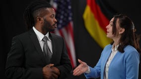 African American and Caucasian politicians thanking audience for attention at press conference shaking hands and looking