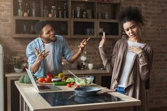 African-american couple cooking and quarreling in loft kitchen Royalty Free Stock Photography African-american couple cooking and quarreling in loft kitchen Royalty Free Stock Photography