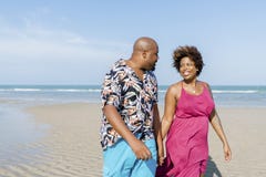 African American couple walking at the beach stock photo African American couple walking at the beach stock photo
