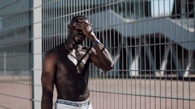 African American male athlete drinking water from bottle splashing water in face cooling down after running workout on stock video African American male athlete drinking water from bottle splashing water in face cooling down after running workout on stock video