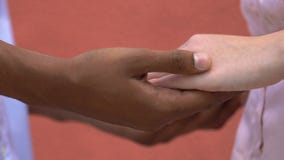 African american male touching caucasian girlfriend hands, tender relations