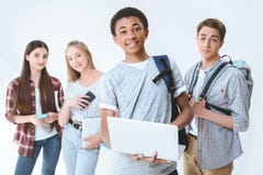 african american teenage boy holding laptop while friends standing near by royalty free stock images african american teenage boy holding laptop while friends standing near by royalty free stock images