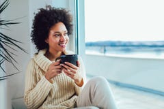 African American woman in her living room drinking holding a coffee tea mug royalty free stock images African American woman in her living room drinking holding a coffee tea mug royalty free stock images