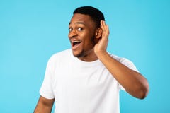 African Man Listening Holding Hand Near Ear On Blue Background Royalty Free Stock Image African Man Listening Holding Hand Near Ear On Blue Background Royalty Free Stock Image