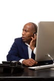 Afrikaanse Amerikaanse Zakenman Listens Through Headset bij Bureau stock afbeelding Afrikaanse Amerikaanse Zakenman Listens Through Headset bij Bureau stock afbeelding