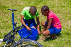 Afrikanische Kinder, die ein Durchbohren auf einem Fahrrad regeln stockfotografie Afrikanische Kinder, die ein Durchbohren auf einem Fahrrad regeln stockfotografie