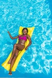 Afrikansk amerikankvinna som svävar på den uppblåsbara madrassen royaltyfri bild Afrikansk amerikankvinna som svävar på den uppblåsbara madrassen royaltyfri bild