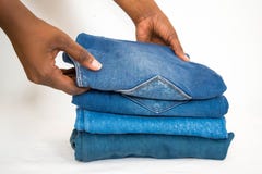 Afrikansk kvinnavikningbunt av jeans eller grov bomullstvill som isoleras på vit bakgrund royaltyfria foton Afrikansk kvinnavikningbunt av jeans eller grov bomullstvill som isoleras på vit bakgrund royaltyfria foton