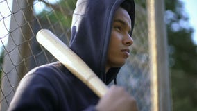 Afro-american teenager holding baseball bat, youth gang in ghetto, closeup stock photos Afro-american teenager holding baseball bat, youth gang in ghetto, closeup stock photos