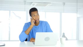 Afro-Amerikaanse mens die op telefoon, het aanwezig zijn vraag op het werk spreken royalty-vrije stock afbeeldingen Afro-Amerikaanse mens die op telefoon, het aanwezig zijn vraag op het werk spreken royalty-vrije stock afbeeldingen