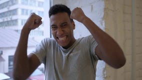 Afro-Amerikaanse Mens die toSuccess in Zolderbinnenland reageren stock afbeelding Afro-Amerikaanse Mens die toSuccess in Zolderbinnenland reageren stock afbeelding